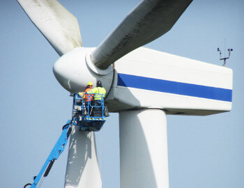 men working up on a high windmill